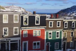a group of colorful buildings in front of a mountain at Downtown Apt #6 Amazing View - 23 Queen's Rd in St. John's