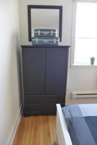 a bedroom with a black dresser with a mirror at Downtown Apt #6 Amazing View - 23 Queen's Rd in St. John's