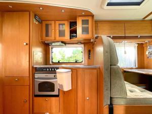 a small kitchen with a stove and a window at Autocaravana Dethleffs Globetrotter in Viana do Castelo