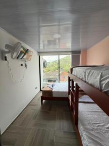 ein Schlafzimmer mit zwei Etagenbetten und einem Fenster in der Unterkunft Hotel Lancan - Pauna, Boyacá in Pauna