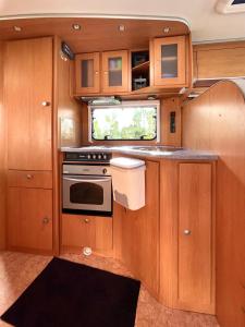 a kitchen with wooden cabinets and a stove at Autocaravana Dethleffs Globetrotter in Viana do Castelo +13 photos