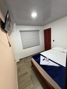 ein Schlafzimmer mit einem Bett und einem Fernseher in der Unterkunft Hotel Lancan - Pauna, Boyacá in Pauna