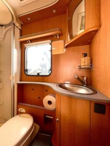 a small bathroom with a sink and a toilet at Autocaravana Dethleffs Globetrotter in Viana do Castelo
