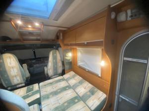 an interior view of an rv with a bed and chairs at Autocaravana Dethleffs Globetrotter in Viana do Castelo