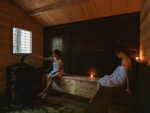 a girl in a room with a woman sitting on a bench at La Terra Resort in Shiojiri
