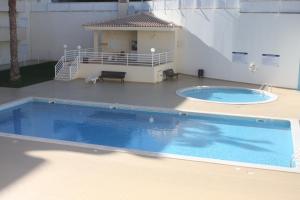 a large swimming pool in front of a building at Albufeira Lovely new Apartment W/ Pool in Albufeira
