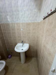 a bathroom with a sink and a toilet at Jassehs Apartments in Brusubi