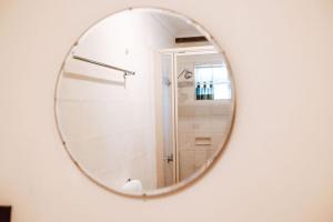 a mirror on a wall with a shower in a bathroom at Tillrander - Scamander Retreat in Scamander +11 photos
