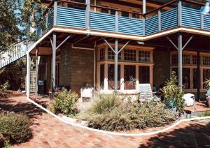 a house with a blue roof and a patio at Tillrander - Scamander Retreat in Scamander
