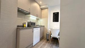 a small kitchen with a counter and a microwave at Sky 401 by CONFORTSKY in Pas de la Casa