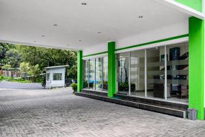 a green and white building with glass windows at RedDoorz Plus near The Great Asia Africa Lembang in Bandung +31 photos