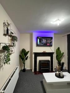 a living room with a fireplace with a tv above it at House in Manchester - G Escape in Manchester
