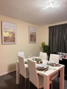 a dining room with a white table and white chairs at House in Manchester - G Escape in Manchester