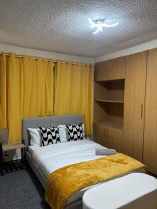 a bedroom with a large bed with yellow curtains at House in Manchester - G Escape in Manchester