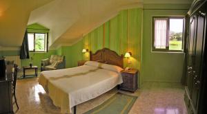 a green bedroom with a bed and a chair at Posada La Anjana in Puente Viesgo