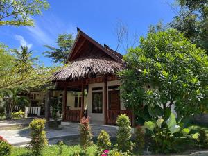 a small house with a straw roof at Leuser Inn & Jungle Trekking in Bukit Lawang