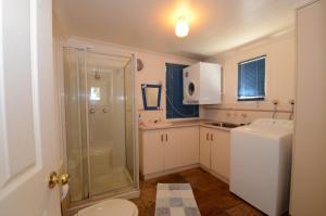 a bathroom with a shower and a toilet and a sink at Seahaven Beach House - Shellharbour in Shellharbour +21 photos