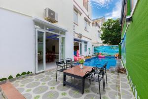 a patio with a table and chairs and a pool at Villa B2-9 Long Cung in Vung Tau