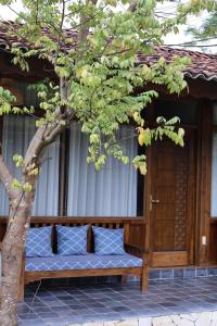 a bench in front of a building with a tree at Cheers Ecolodge Du Già in Làng Cac