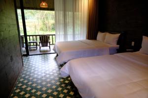 a hotel room with two beds and a balcony at Cheers Ecolodge Du Già in Làng Cac