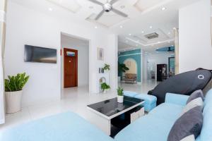 a living room with a blue couch and a tv at Villa B2-11 Long Cung in Vung Tau