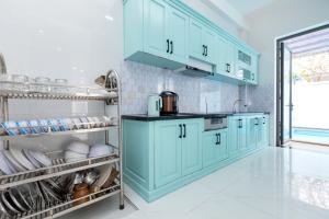 a kitchen with turquoise cabinets and a sink at Villa B2-11 Long Cung in Vung Tau