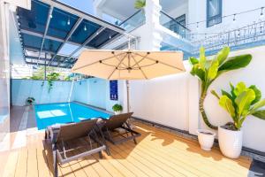 a patio with a table and chairs and an umbrella at Villa B2-11 Long Cung in Vung Tau