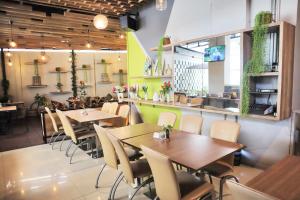 a restaurant with tables and chairs in a room at Whiz Hotel Cikini Jakarta in Jakarta