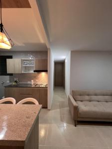 a living room with a couch and a kitchen at Ruby Suites I Apto en Valledupar I Lujo y Confort I Aire en todas las habitaciones in Valledupar