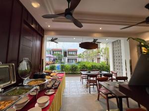 a restaurant with a long buffet with tables and chairs at Happy Resort Siem Reap in Phumi Ta Phul