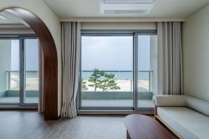 a living room with a couch and a large window at Cabinet 캐비넷 양양 in Yangyang