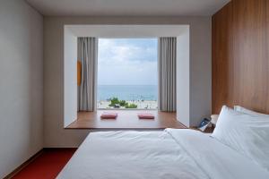 a bedroom with a bed and a view of the ocean at Cabinet 캐비넷 양양 in Yangyang