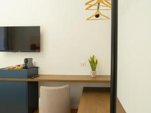 a desk with a chair and a television on a wall at Cala Bianca in Trani