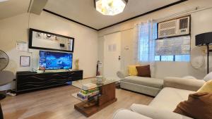 a living room with a couch and a tv at Raed Homestay by ASH in Biñan