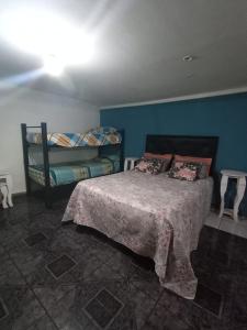 a bedroom with a bed and a blue wall at la reyna in Monte Grande
