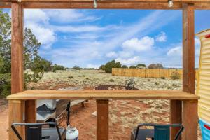 a view of a yard from a porch with two chairs at Grand Canyon Stargazing Camper in Williams