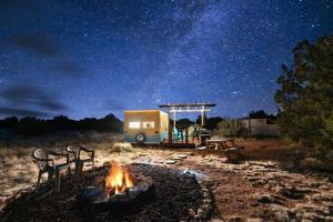 a camper parked under a starry sky with a camp fire at Grand Canyon Stargazing Camper in Williams +30 photos