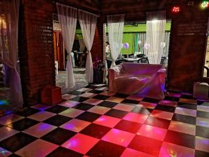 a room with a checkered floor with a bed and a table at la reyna in Monte Grande