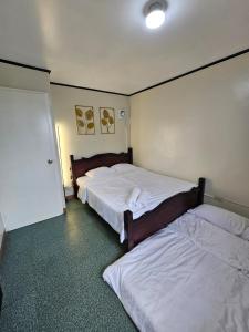 a bedroom with two beds and a door to another room at Raed Homestay by ASH in Biñan