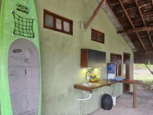 a room with a desk and a surfboard on the wall at Porto Taipu in Marau