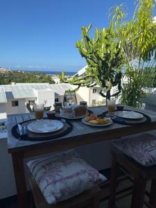 a table with plates of food on a balcony at Ti Coin Soleil in Saint-Paul