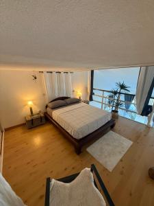 a bedroom with a bed and a large window at Ti Coin Soleil in Saint-Paul
