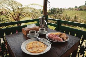 a table with two plates of food on top at D'Ume Bendoel Homestay in Jatiluwih