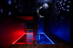 a man standing in a room with red and blue lights at abrAsus house Fuji in Narusawa