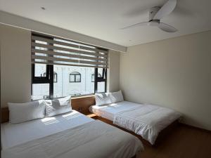 two beds in a room with a window at Toàn Thịnh Hotel in Da Lat