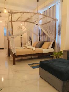a bed with a canopy in a room at The wave Dickwella in Dickwella +47 photos
