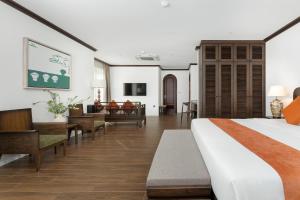 a hotel room with a bed and a living room at Paul Chabot Hotel in Hai Phong