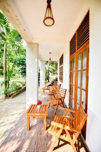 a group of benches on the porch of a house at Summerland Residence in Udawalawe