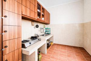 a small kitchen with wooden cabinets and a sink at RedDoorz Syariah at Cimahi in Cimindi