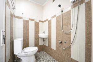 a bathroom with a toilet and a shower at RedDoorz Syariah at Cimahi in Cimindi +15 photos